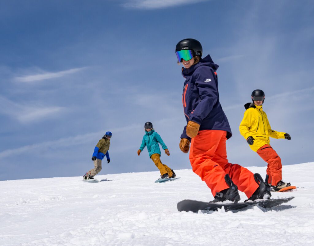 Three snowboarders learning with an instructor